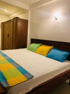 een slaapkamer met een groot bed met kleurrijke kussens bij White Villa Ella/ Badulla in Badulla