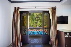 Goa Villagio Resort & Spa - A Unit of IHM, 10 Min Walk from Beach的电视和/或娱乐中心