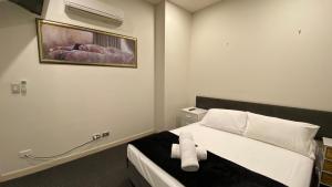 a bedroom with a bed with a towel on it at Solaire Apartments in Gold Coast