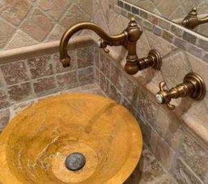 La salle de bains est pourvue d'un lavabo en bois et d'un robinet. dans l'établissement Jolie Maison Jardin Piscine, à Narbonne