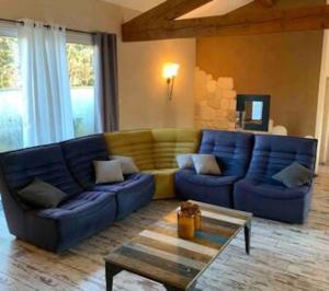a living room with a blue couch and a table at Jolie Maison Jardin Piscine in Narbonne