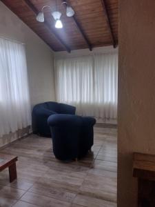 a living room with two blue chairs and a couch at Sobrado recanto som das águas in Santo Amaro da Imperatriz