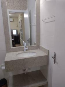 La salle de bains est pourvue d'un lavabo et d'un miroir. dans l'établissement Sobrado recanto som das águas, à Santo Amaro da Imperatriz