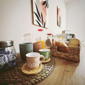 einen Tisch mit Kaffeetassen und einen Korb Brot in der Unterkunft B&B Le Chicche di Lulu' in Borghetto