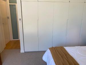 a bedroom with white cabinets and a bed at Seaside Escape in Sydney