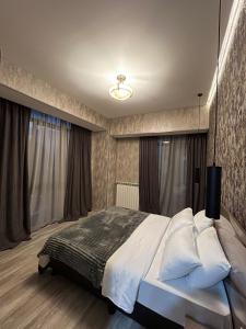 een slaapkamer met een groot bed en gordijnen bij Tbilisi App 2 in Tbilisi City
