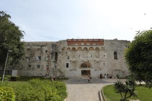 a large stone building with people standing in front of it at Golden Gate Dream Rooms in Split