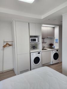 a kitchen with two washer and dryers in a room at Sokcho Summitbay 1209 "Ocean View" in Sokcho