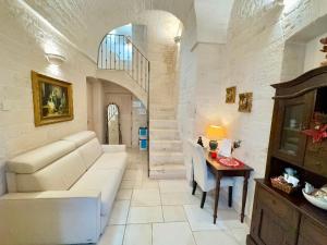 a living room with a white couch and a table at Trulli Contento - Rooms & Apartments in Alberobello