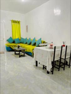 a living room with a yellow couch and a table at My Lovely Apartment in Dipolog