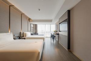 a hotel room with two beds and a table at Atour Hotel Hefei USTC Huangshan Road in Hefei