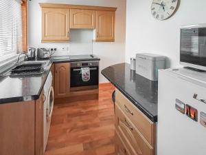 eine Küche mit Holzschränken und einer Arbeitsplatte in der Unterkunft Hynish House in Stornoway