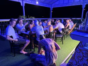 a group of people sitting at tables in a bar at Apsara Koh Rong Guesthouse in Koh Rong Island