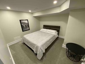 ein Schlafzimmer mit einem großen Bett und einem Tisch in der Unterkunft 3 Bedroom Home, 3 Queen Beds, Close To All Amenities in Ottawa