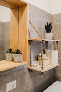 ein Badezimmer mit einem Regal mit Pflanzen und Handtüchern in der Unterkunft VEryNICE - New Cozy Family Apartment near Venezia Mestre in Mestre