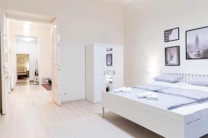 een witte slaapkamer met een groot wit bed. bij Sweet Relax House in Boedapest