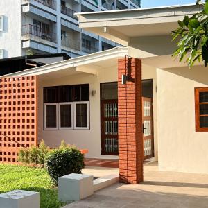 une maison avec pilier en briques devant un bâtiment dans l'établissement Ray's Home,3BR with front yard,walkable to Nimman, à Chiang Mai