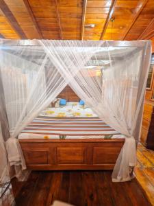 Łóżko w pokoju z moskitierą w obiekcie Little Pumpkin Cabanas w Tangalli
