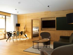sala de estar con TV, mesa y sillas en My Heimat 1495 Arlberg, en Schröcken