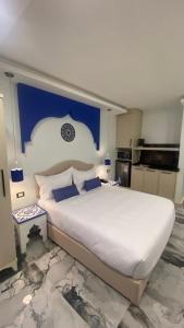um quarto com uma cama grande e uma parede azul em Amman Trail Hotel & Studios em Amã