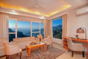 a living room with a couch and chairs and windows at Yog Wellness Resort & Spa By Amritara in Mussoorie