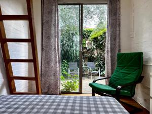 a bedroom with a green chair and a window at Zion in Sydney