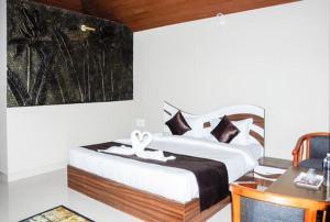 a bedroom with a large bed and a desk with a desk at Coorg Annu Stay in Madikeri