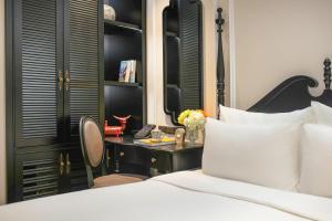 a bedroom with a bed and a desk at Amira Hotel Hanoi in Hanoi
