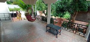 un portico con due sedie e un'altalena di HILL VIEW HOTELS a Yelagiri