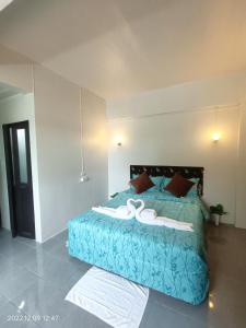 a bedroom with a bed with a blue comforter at Funky Crab The River in Krabi town