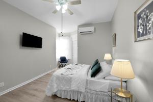 a white bedroom with a bed and a ceiling fan at Univ City Drexel 2 Bdrm Lovely Unit in Philadelphia