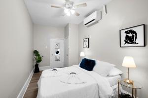 a white bedroom with a bed and a ceiling fan at Univ City Drexel 2 Bdrm Lovely Unit in Philadelphia
