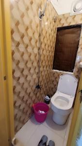 a small bathroom with a toilet and a red bucket at MJ Home in Manila
