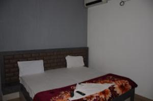 a bedroom with a bed with white sheets and pillows at Hotel Rajawat , Madhya Pradesh in Vidisha