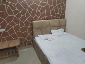 a bed in a room with a patterned wall at Hotel Rajawat , Madhya Pradesh in Vidisha