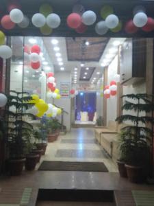 a hallway with balloons and plants in a building at Hotel Rajawat , Madhya Pradesh in Vidisha