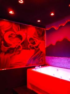 une chambre rouge avec un cœur peint sur le mur dans l'établissement la coquine, love room, romantique, à Toulon