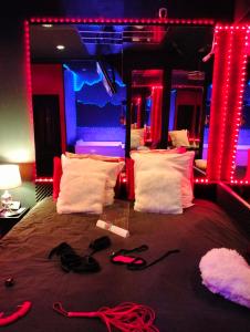 a bedroom with a bed with red and blue lights at la coquine, love room, romantique in Toulon