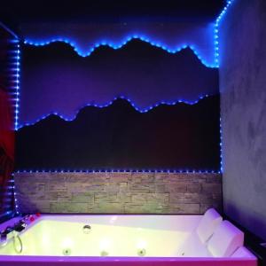 une baignoire avec des lumières bleues sur un mur dans l'établissement la coquine, love room, romantique, à Toulon