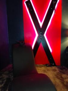 krzesło przed czerwonym neonem w obiekcie la coquine, love room, romantique w mieście Tulon
