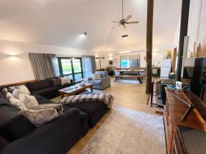 a living room with a couch and a tv at Tikitere Lodge, Rotorua in Rotorua