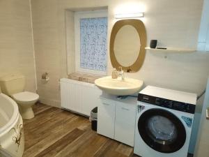a bathroom with a washing machine and a sink at "Fürstenhaus-OG" 3-ZKBB Hofgeismar-Zentrum! in Hofgeismar +16 photos