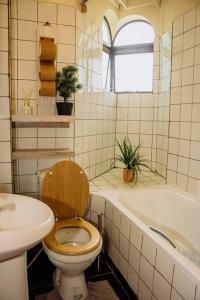 a bathroom with a toilet and a sink and a tub at The happy place - Westlands, Nairobi in Nairobi
