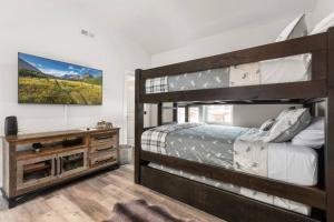 1 Schlafzimmer mit 2 Etagenbetten und einem TV in der Unterkunft Mountain View Retreat at The Quarry - Sleeps 10! in Whitefish
