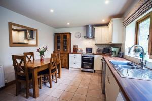 a kitchen with a table and chairs and a sink at Cabalva Mill Cottage - very private and with views over the River Wye in Clifford