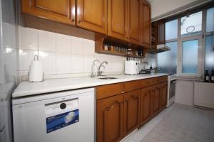 - une cuisine avec des placards en bois et un lave-vaisselle blanc dans l'établissement Shared apartment at Şişli(private room), à Istanbul