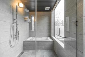 a bathroom with a shower and a tub and a sink at Villa Yin Niseko in Kutchan