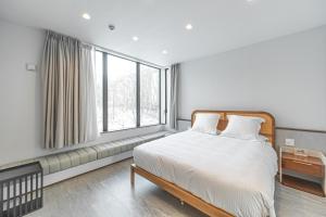 a bedroom with a bed and a large window at Villa Yin Niseko in Niseko