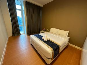 um quarto de hotel com uma cama grande e uma janela em The Platinum Kuala Lumpur by Aurora em Kuala Lumpur