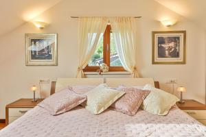 1 dormitorio con 1 cama con almohadas rosas y blancas en Villa Tomislav en Split